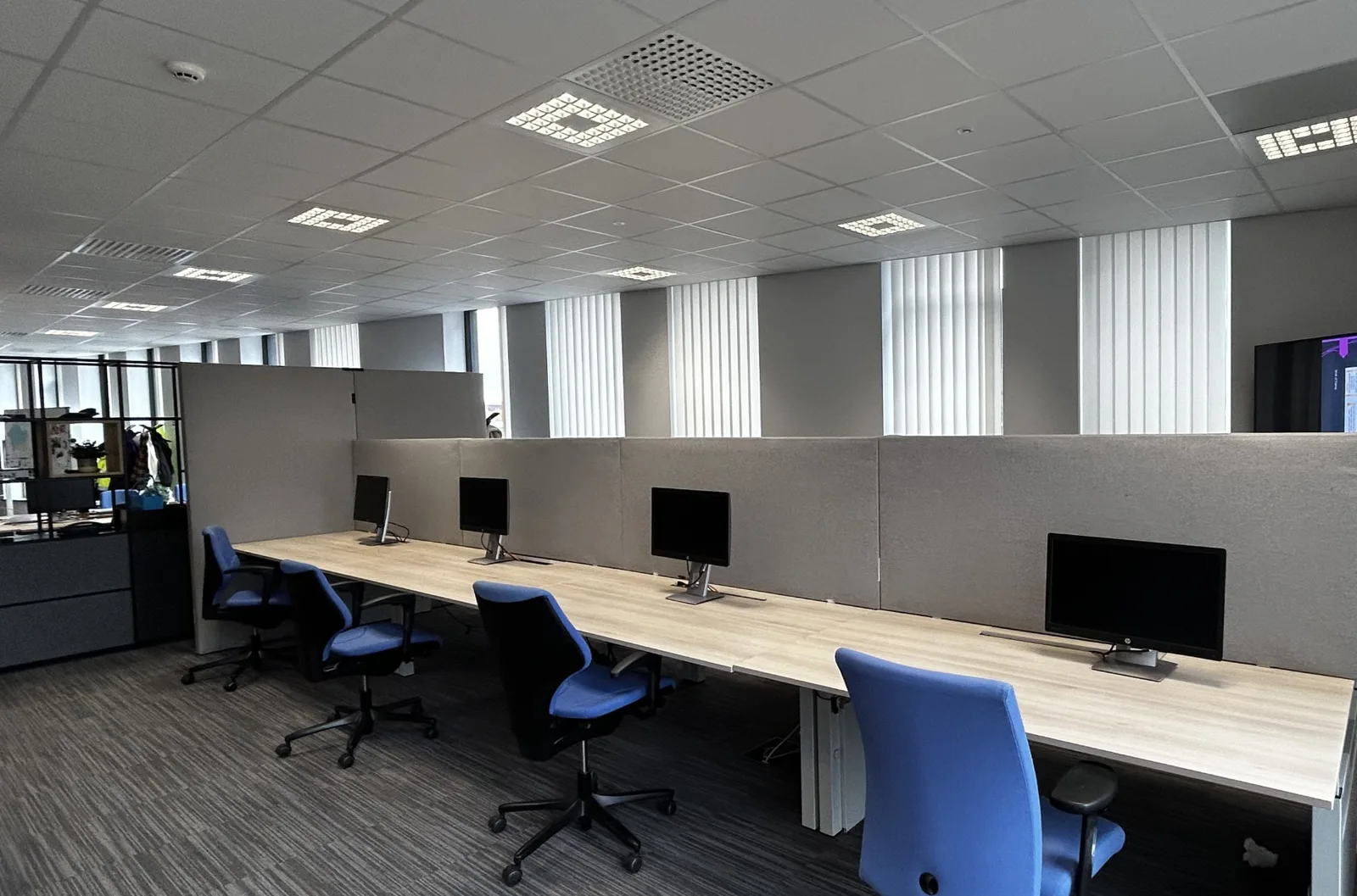 Grijs akoestisch bureauscherm aan een werkplek