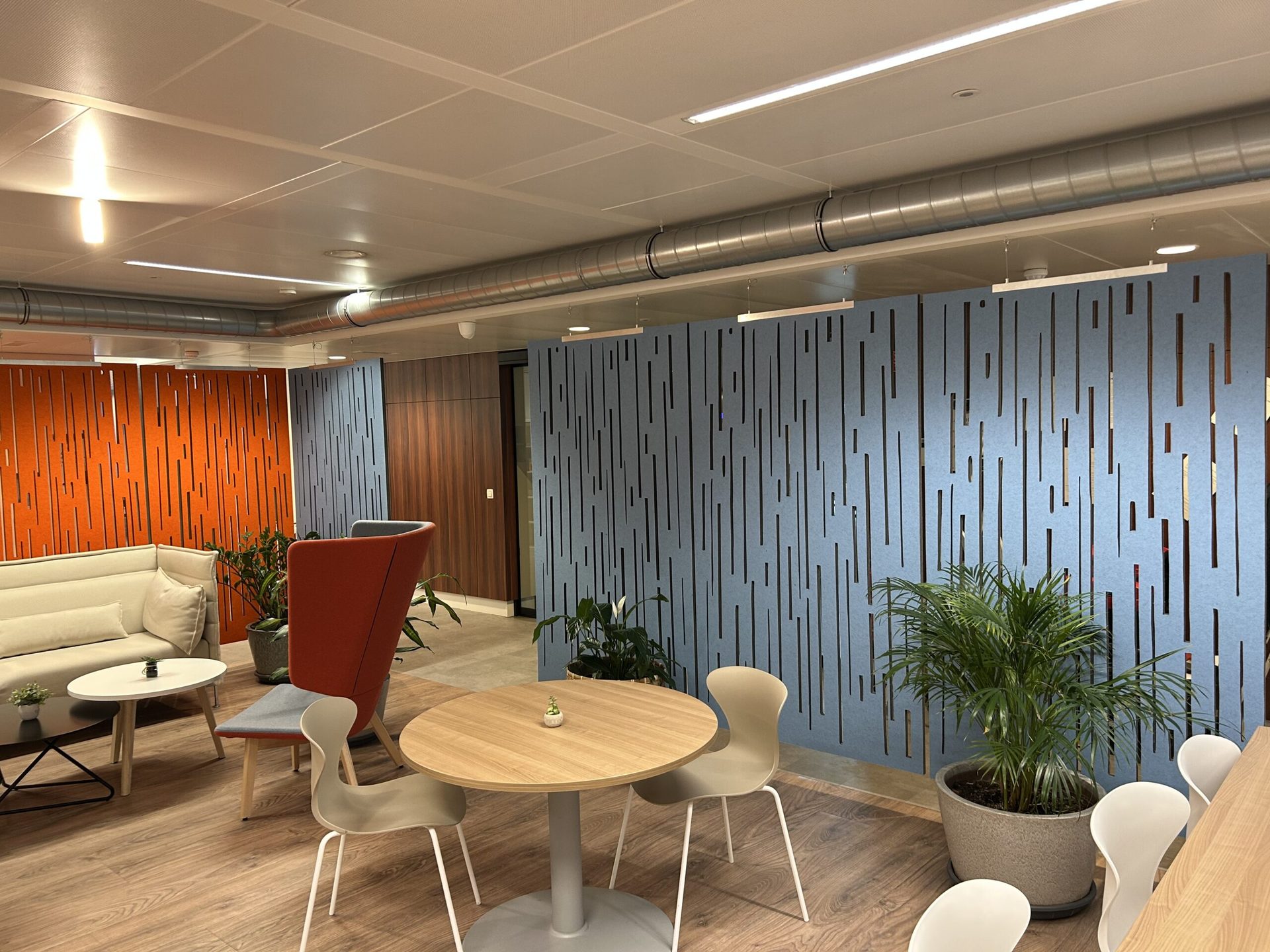 Akoestische wandpanelen met houten lamellen in een loungeruimte