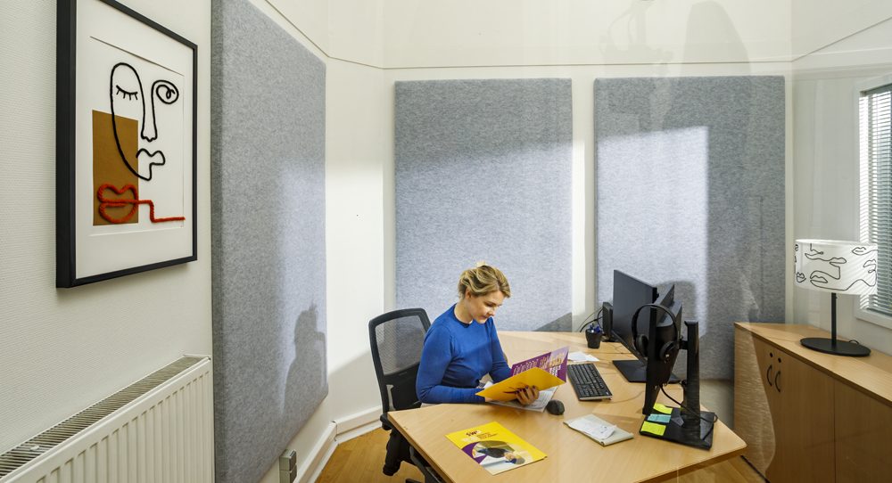 Akoestische wandpanelen achter een werkplek in een kantoorruimte
