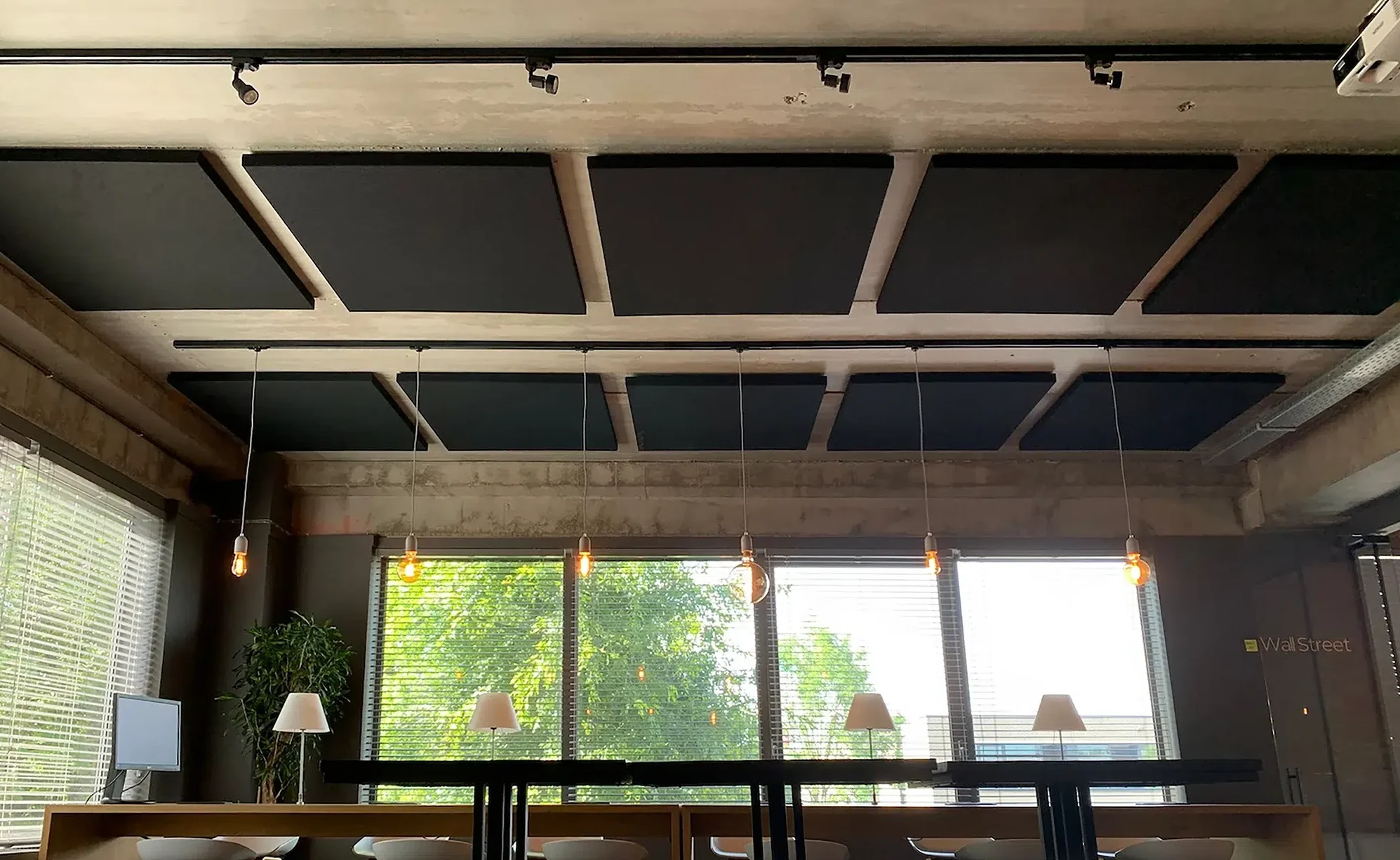 Panneaux de plafond acoustiques au-dessus de tables de travail dans un bureau